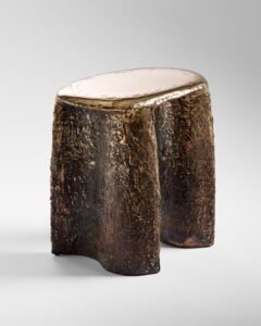 terraforge bronze stool sculptural furniture.jpgBespoke cast bronze stool featuring a highly polished, smooth metallic seat transitioning into a heavily textured, dark patinated organic base, shown against a studio backdrop.