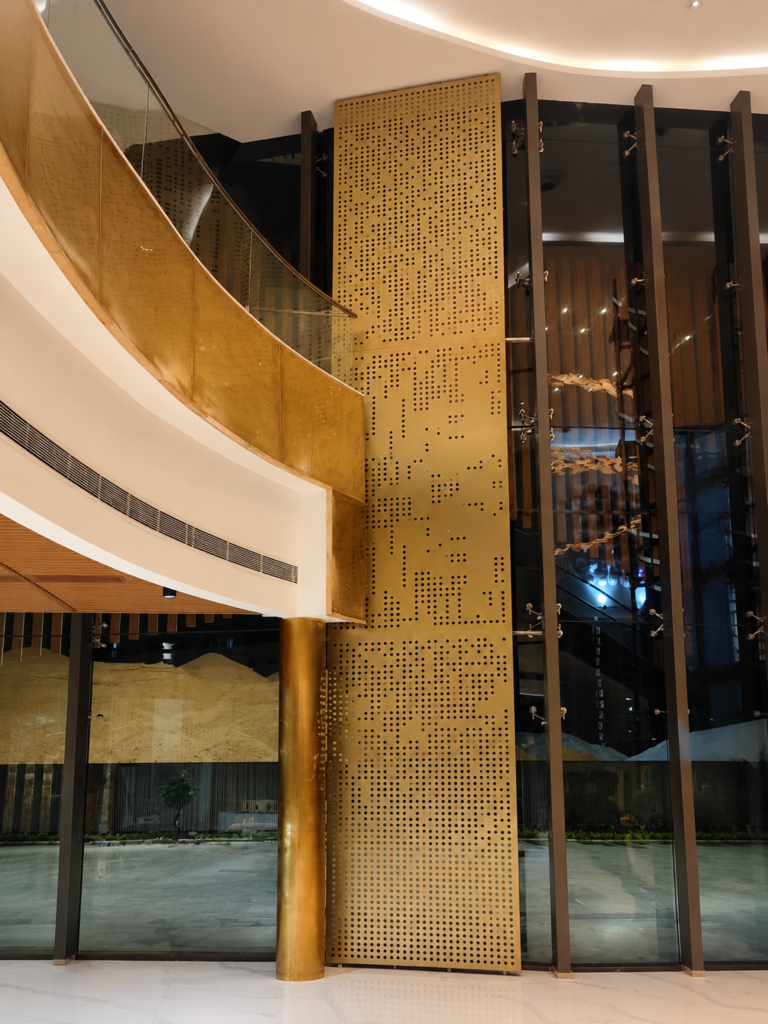 Decorative perforated metal screen installed in a luxury double-height lobby.