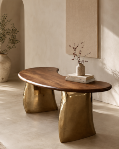 Ultra-realistic organic designer table featuring a sculpted walnut wood top and brass-finished metal base in a warm beige contemporary interior.