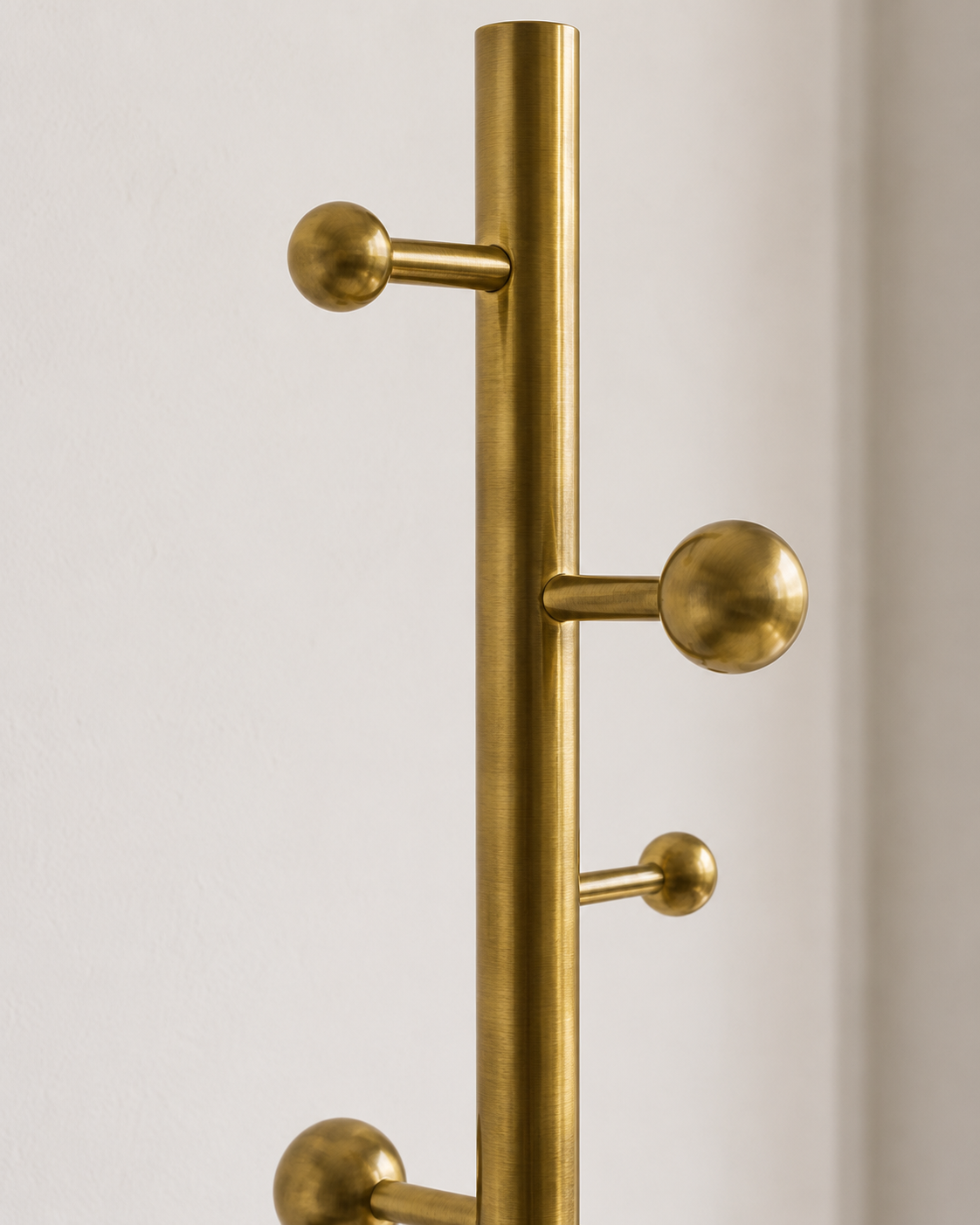 Modern Brass Floor Coat Stand for Bedroom & Entryway Modern brushed brass freestanding coat stand with multiple hooks in a minimalist bedroom interior.